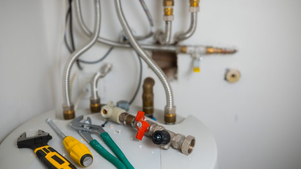 Homeowner plumbing tools including drain snake plunger and adjustable wrench