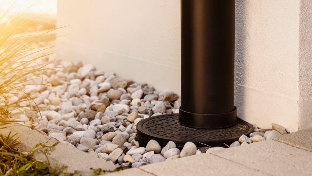 French drain trench with gravel and perforated pipe being installed