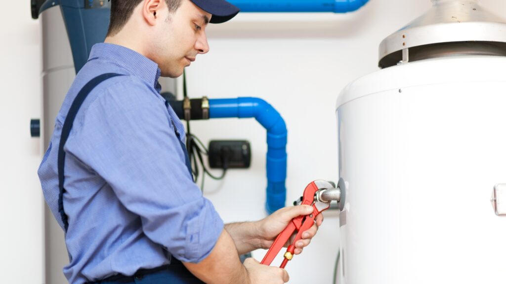 Plumber inspecting a geyser and timer system during maintenance